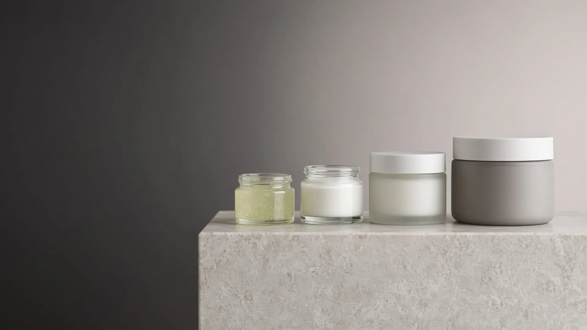 Four unlabeled jars in graduated sizes on a stone plinth