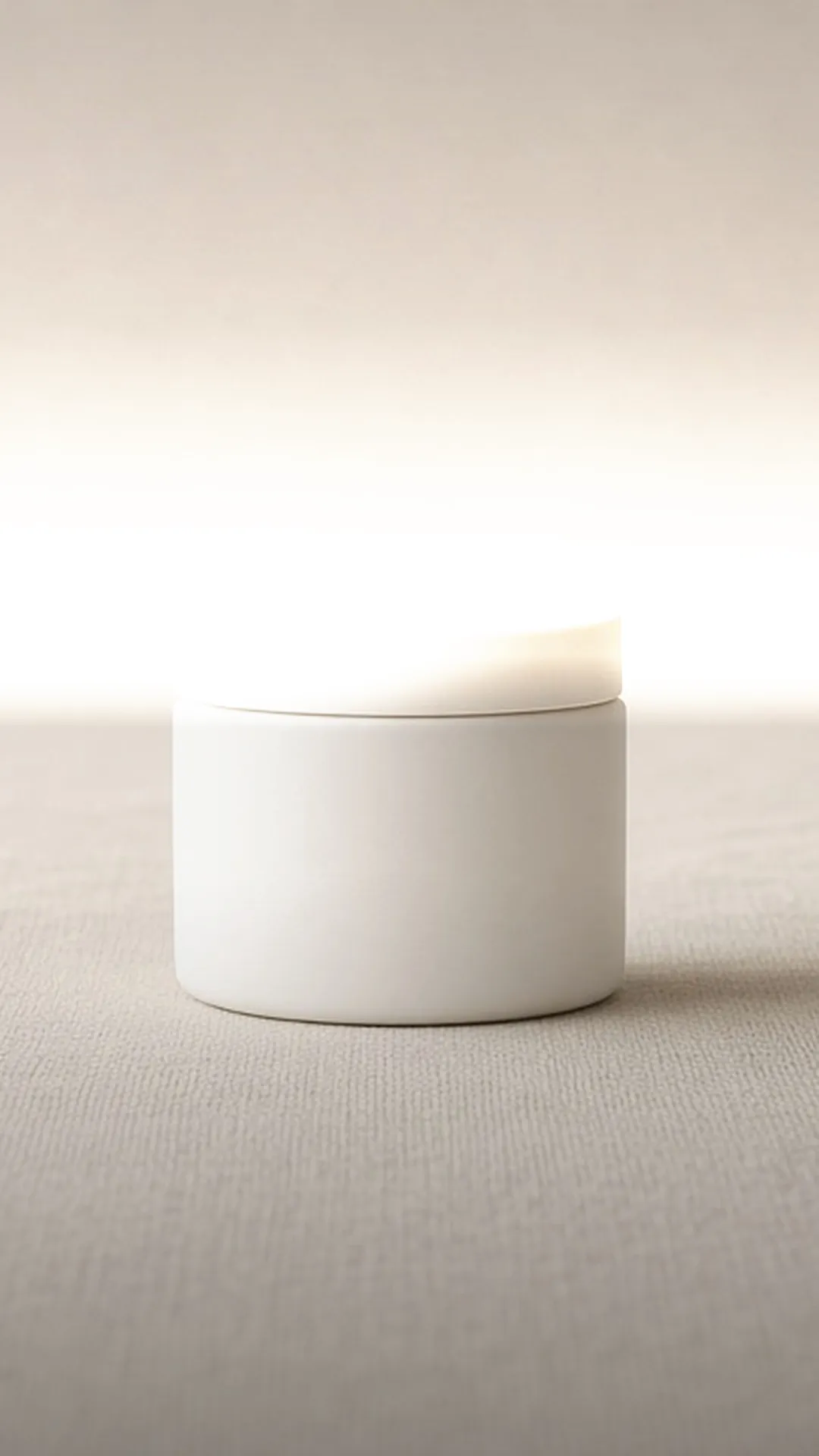 A single white jar on undyed linen